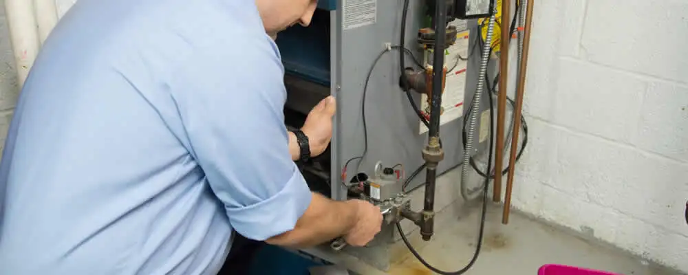 Furnace repair technician inspecting and servicing a home heating system in Escondido, CA