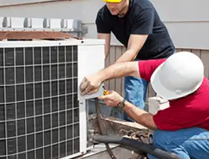 HVAC technicians repairing an outdoor AC unit on a rooftop in Escondido, CA