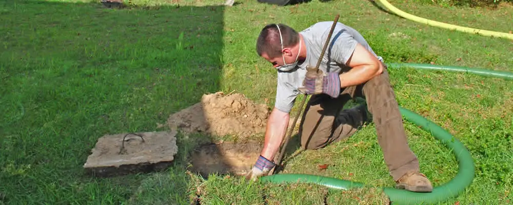Septic pumping technician servicing a residential septic tank in Escondido, CA